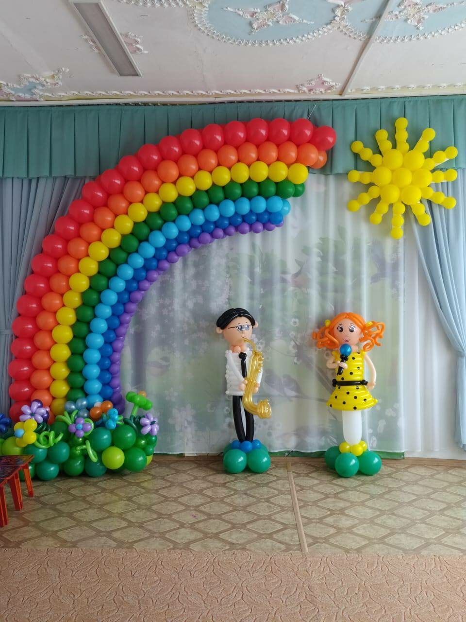 Радуга и фигуры из шаров на сцене актового зала